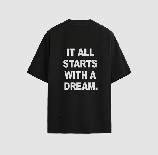 Back of a black t-shirt with the text ‘It all starts with a dream’ in white letters.